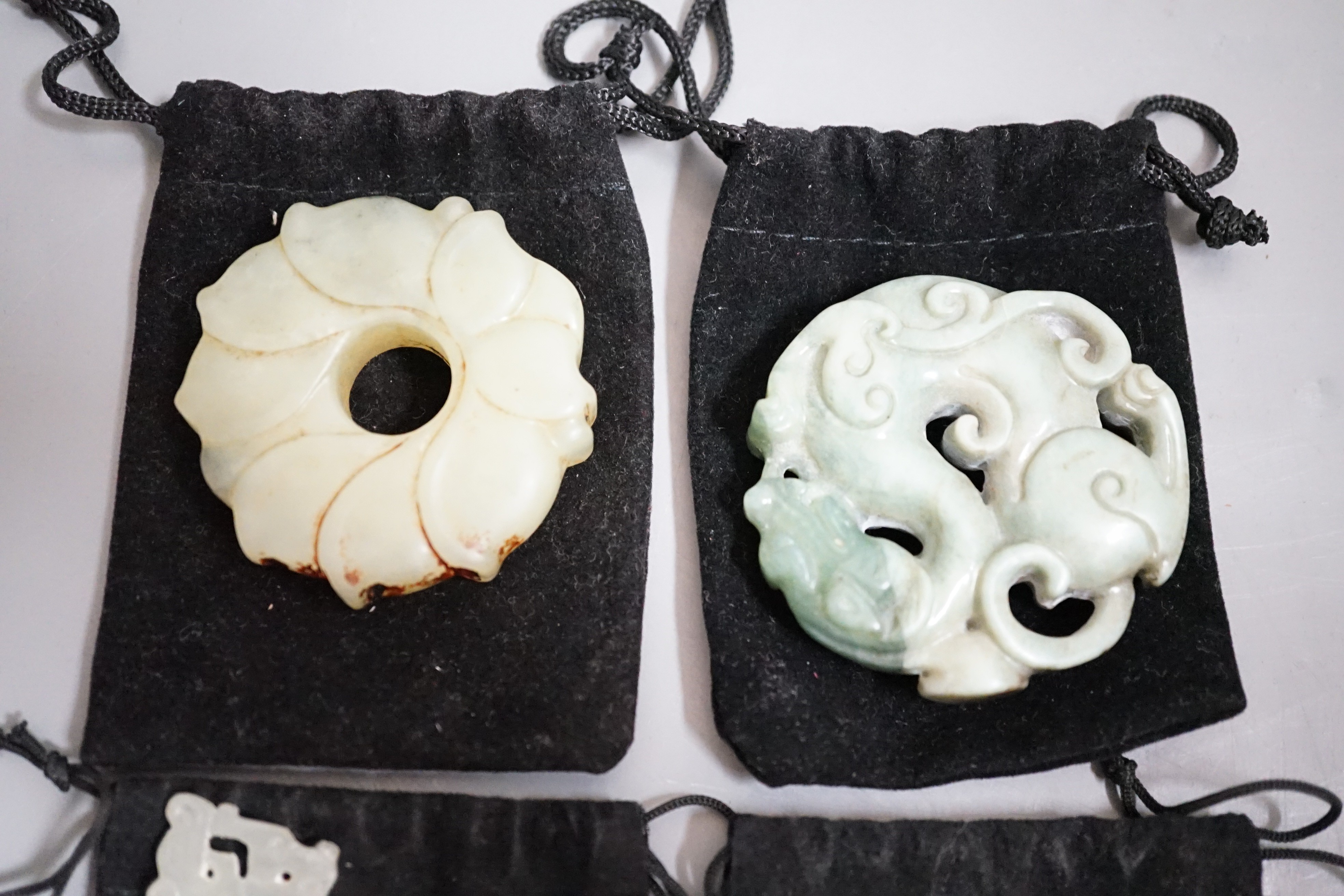 Three Chinese jade celadon roundels/pendants and a huang plaque, carved dragon roundel 5.5 cms diameter (4)